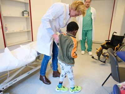 Kiame übt mit Dr. Katrin Rosery das Laufen.