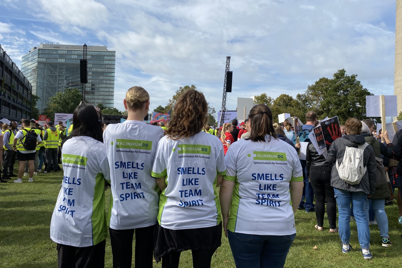 Bild zeigt Mitarbeiter des Klinikum Dortmund bei der Protestaktion in Düsseldorf, die ein T-Shirt mit dem Aufdruck "Smells like team spirit" tragen.