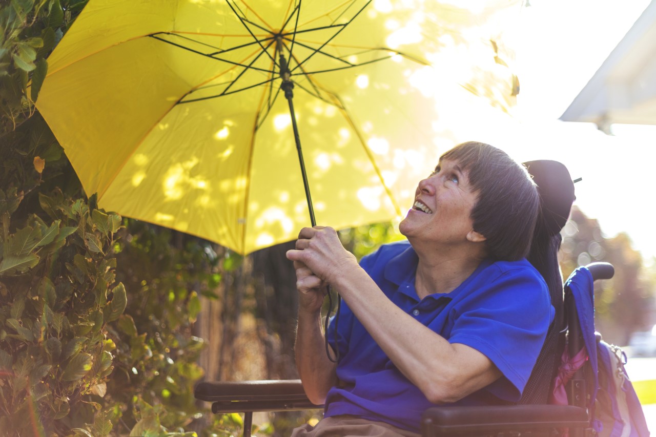 Eine Frau schützt sich mit einem Schirm vor Sonne und Hitze.