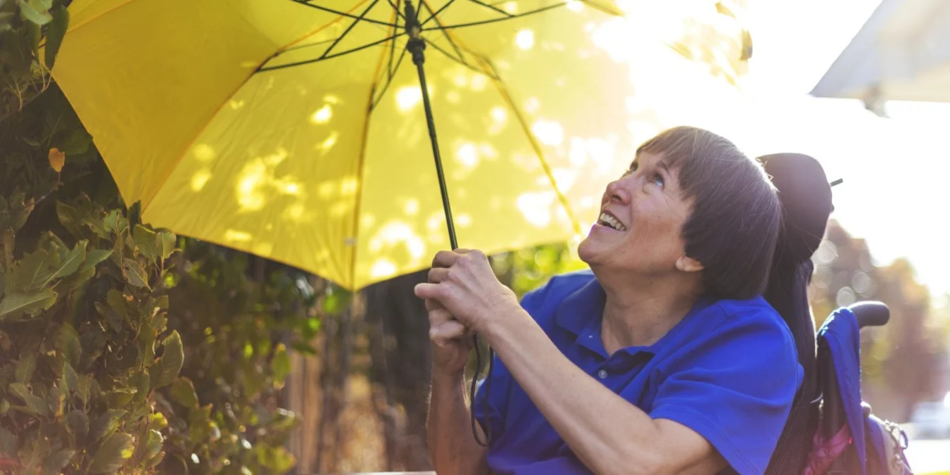 Eine Frau schützt sich mit einem Schirm vor Sonne und Hitze.